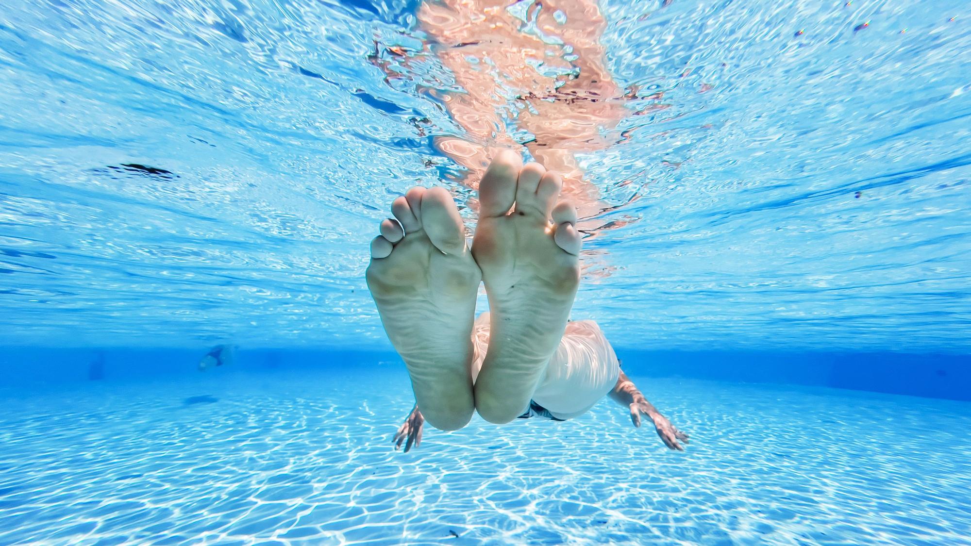 Eine Frau treibt im kühlen Wasser eines privaten Pools in der Region Hannover.