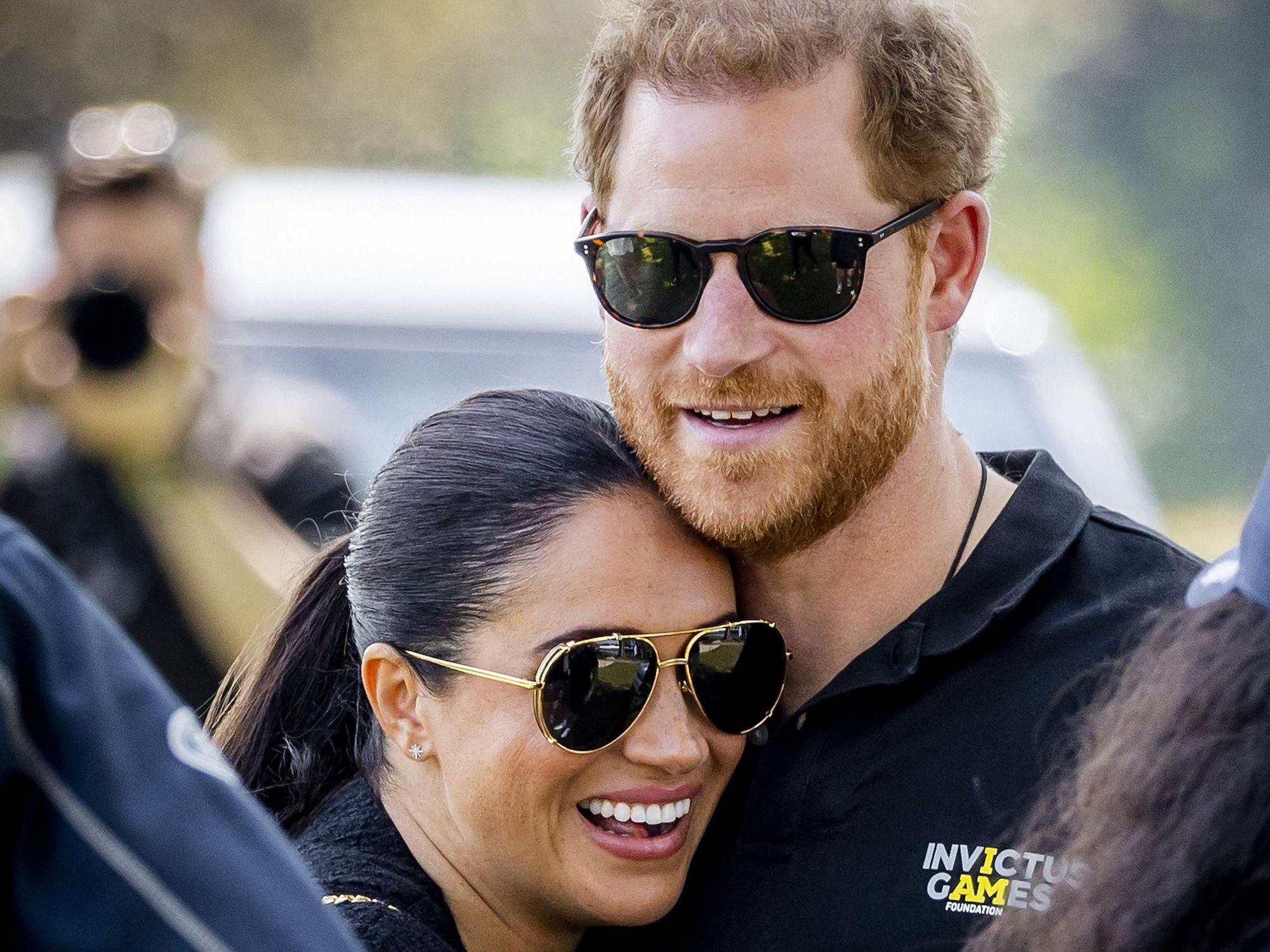 Prinz Harry und Meghan Markle umarmen sich.