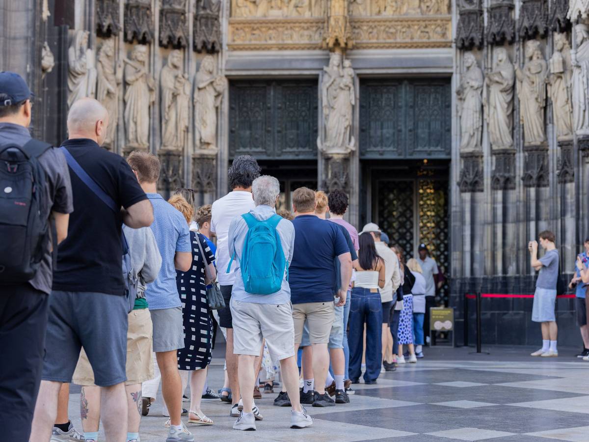 Touristen stehen vor dem Haupteingang des Kölner Doms.