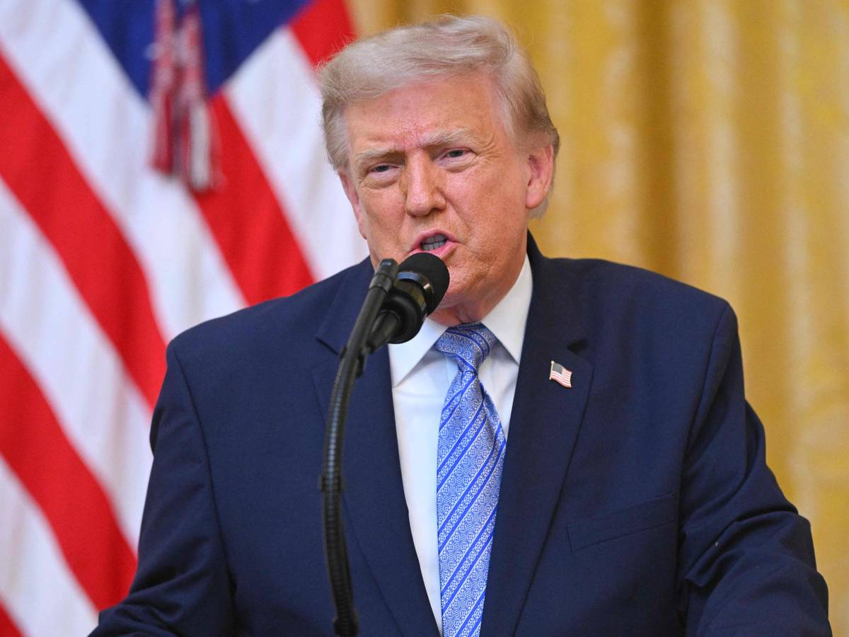 Donald Trump spricht bei einer Rede an die Nation in ein Mikrofon, im Hintergrund die US-Flagge.