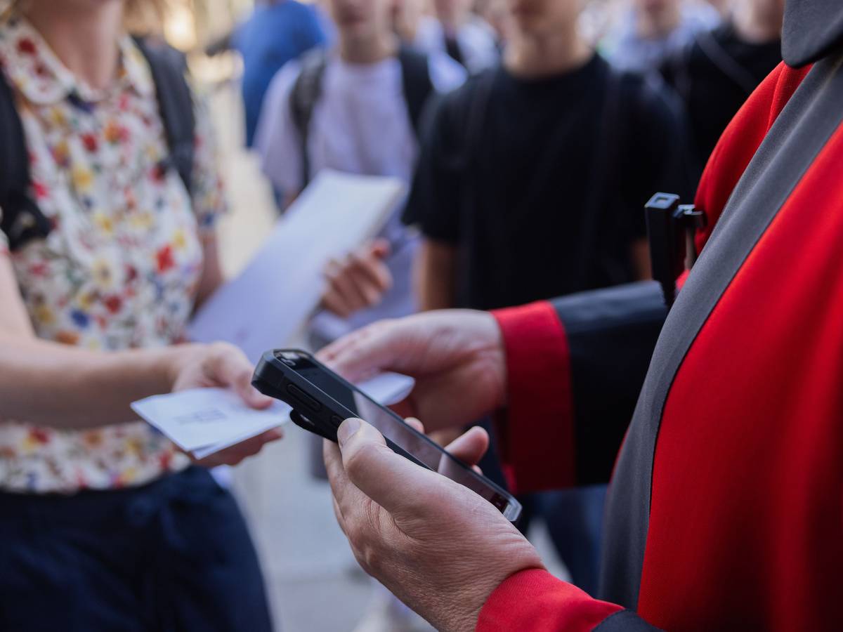 Ein Domschweizer kontrolliert ein Ticket vor dem Haupteingang des Kölner Doms. Der Eintritt in den Kölner Dom kostet seit dem 1. Juli zwölf Euro für Besucher und Besucherinnen.