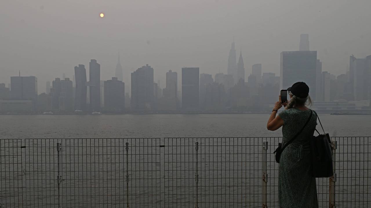Eine Touristin fotografiert die Skyline von Manhattan, die Sicht ist schlecht.
