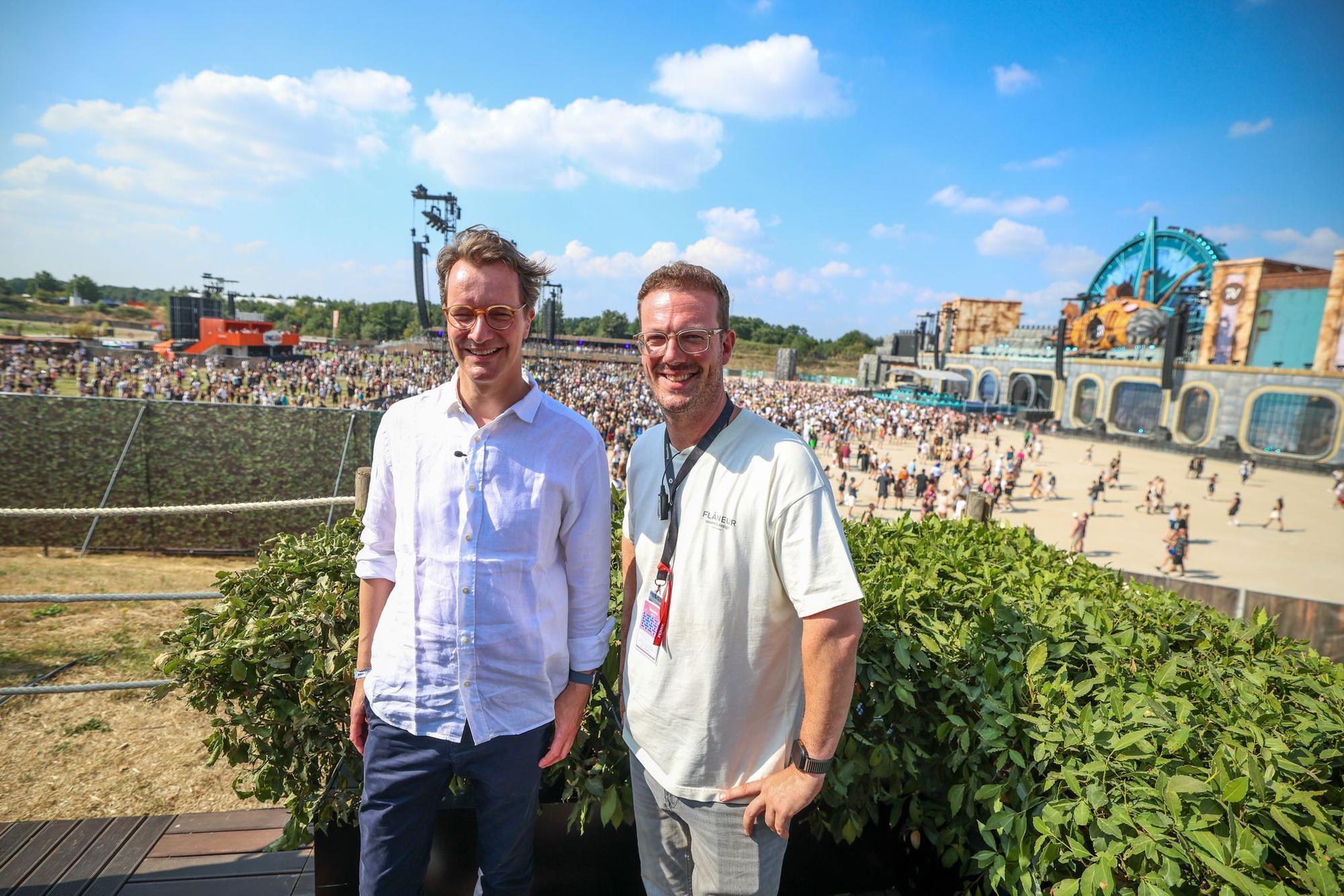 NRW-Ministerpräsident Hendrik Wüst (CDU, links) Parookaville-Chef Bernd Dicks stehen im VIP-Bereich vor der großen Hauptbühne.