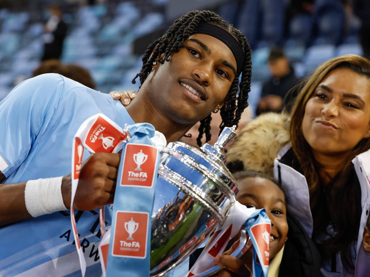 Reigan Heskey feiert mit einem Pokal in den Händen.