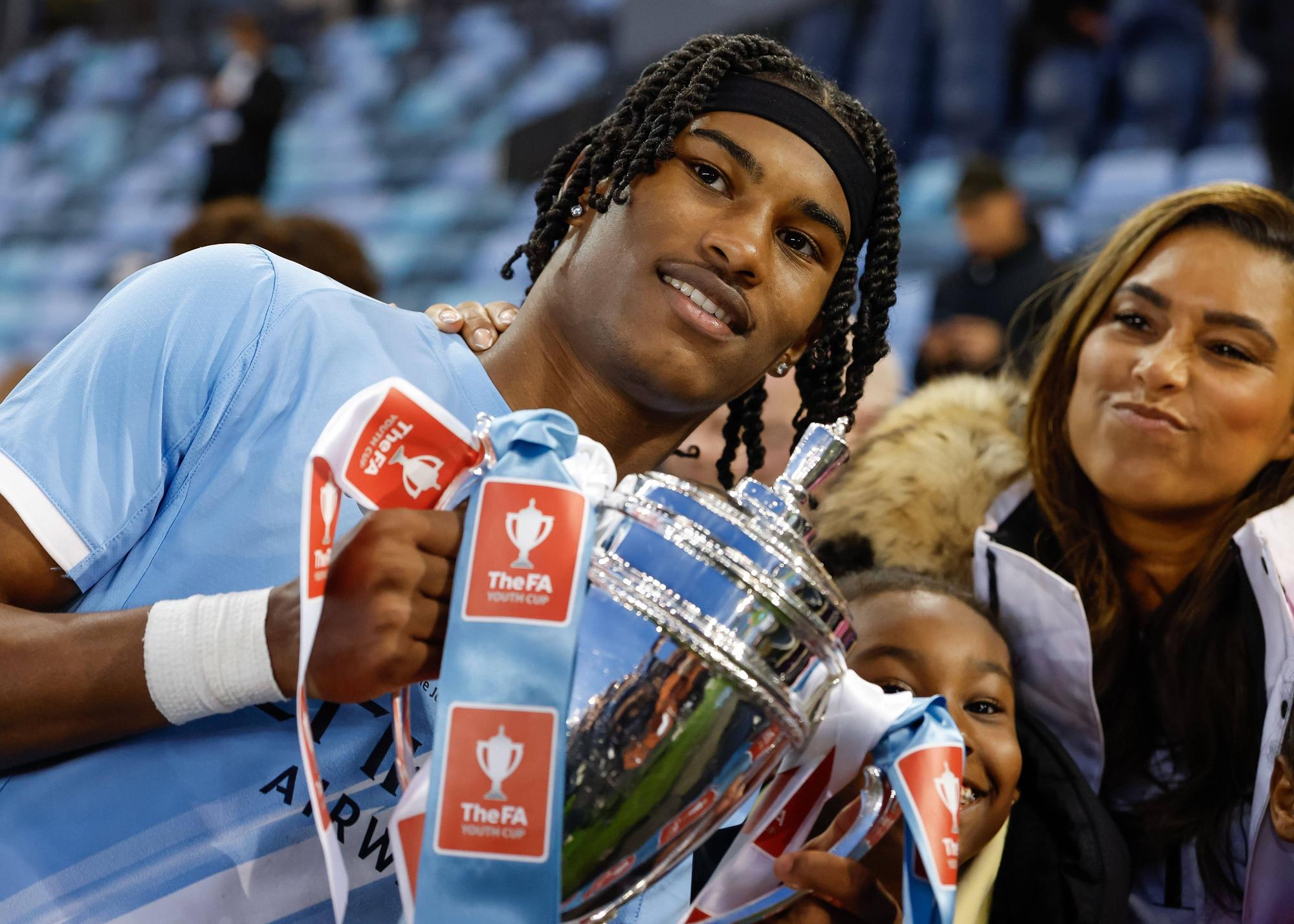 Reigan Heskey feiert mit einem Pokal in den Händen.