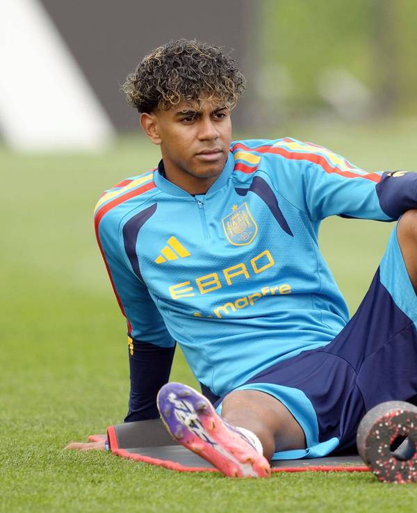 Lamine Yamal sitzt beim Training auf einer Matte und dehnt sich.