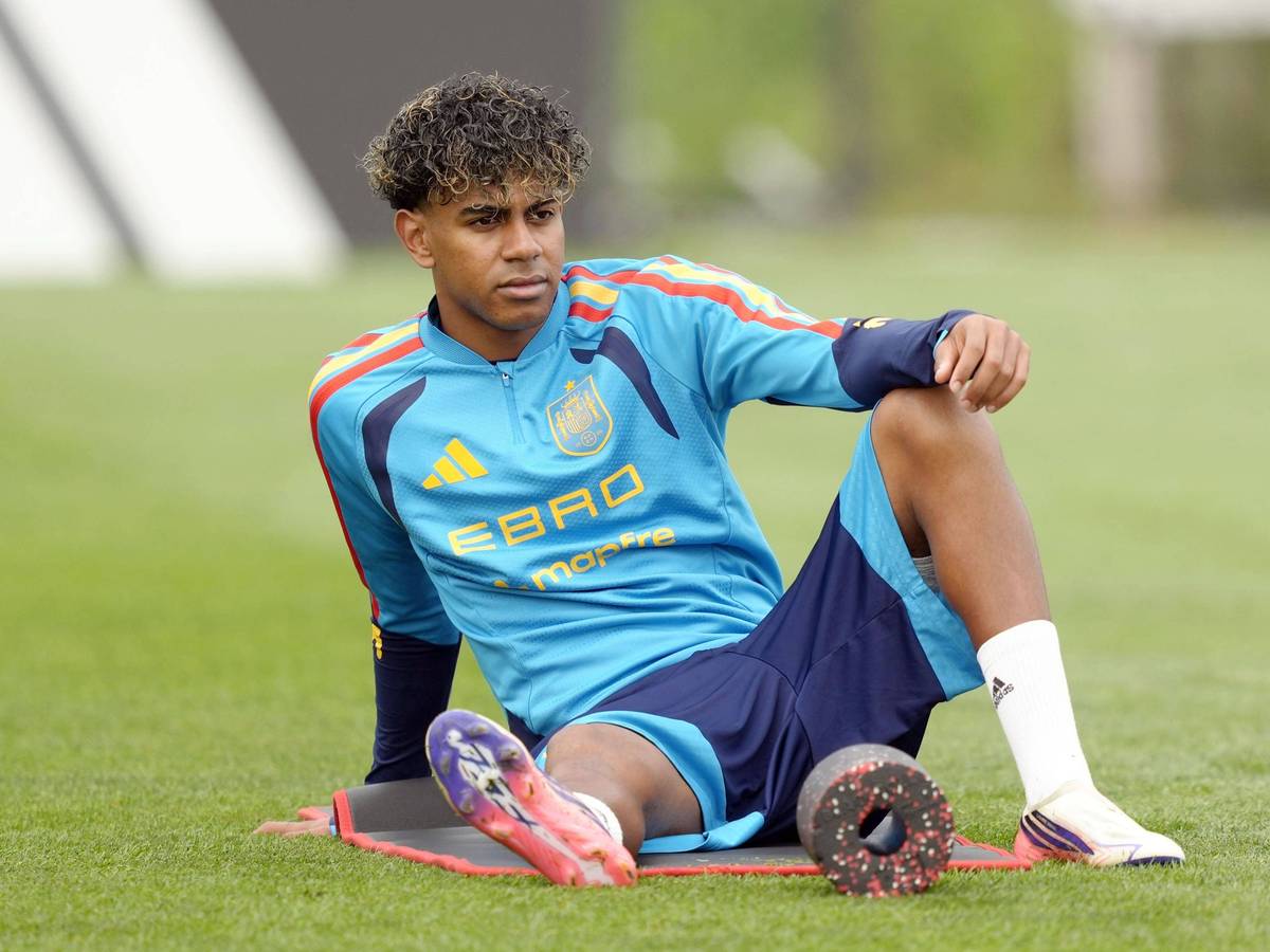 Lamine Yamal sitzt beim Training auf einer Matte und dehnt sich.
