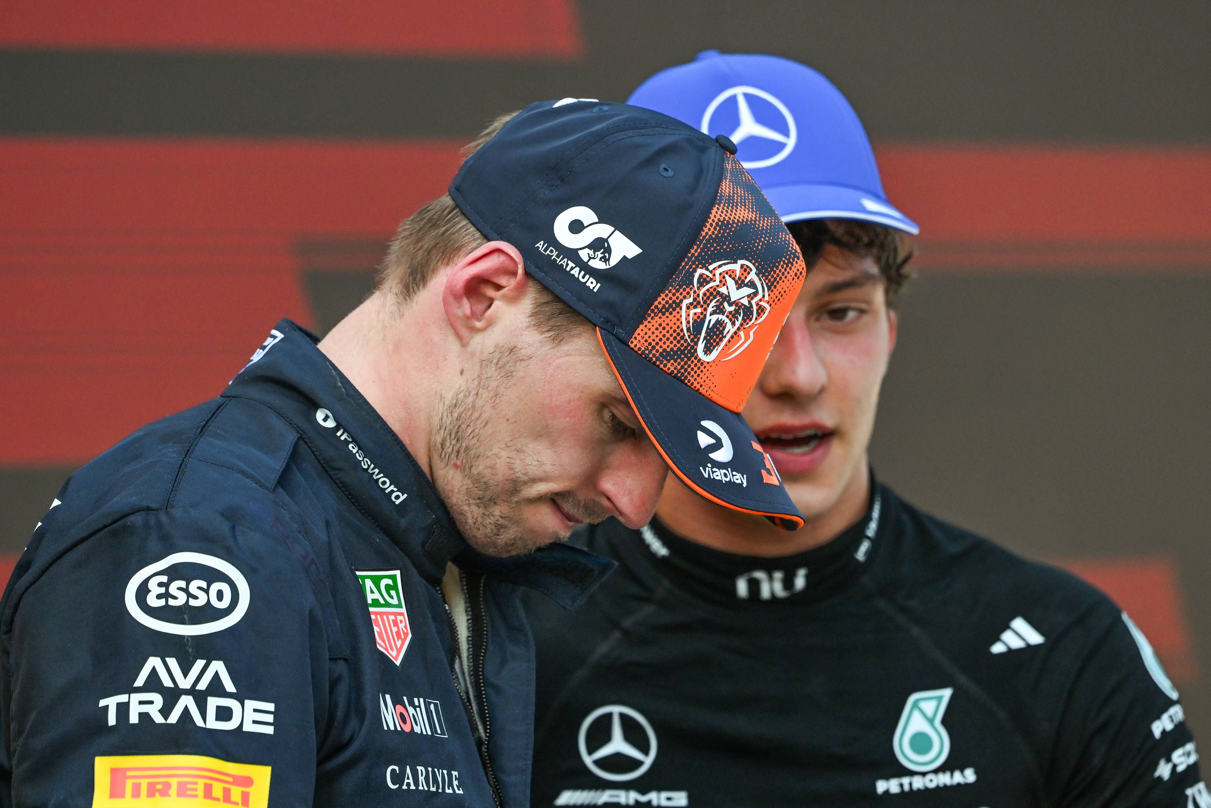 Kimi Antonelli (im Hintergrund) und Max Verstappen unterhalten sich.