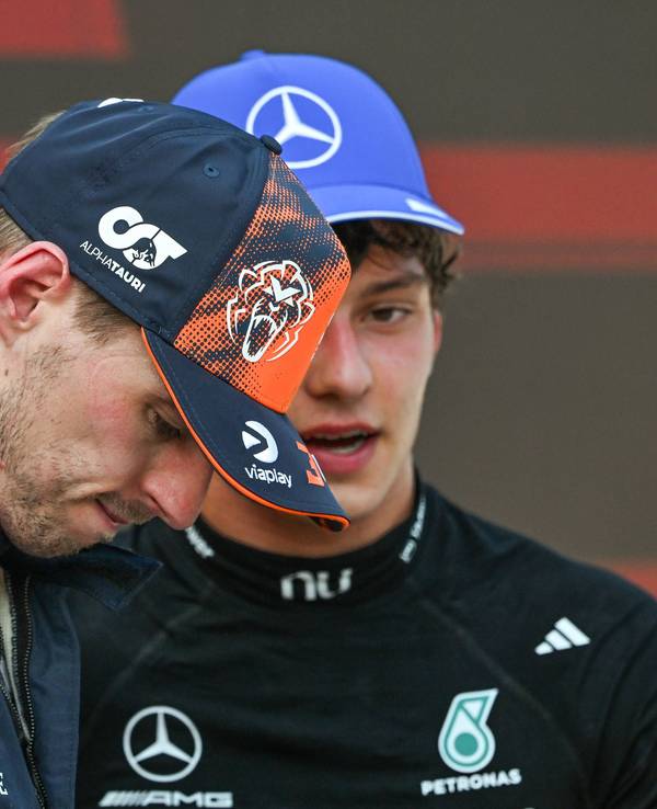 Kimi Antonelli (im Hintergrund) und Max Verstappen unterhalten sich.