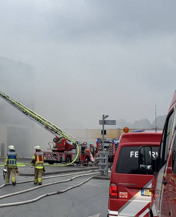 Feuerwehrleute löschen einen Brand auf einem Recyclinghof in Duisburg.