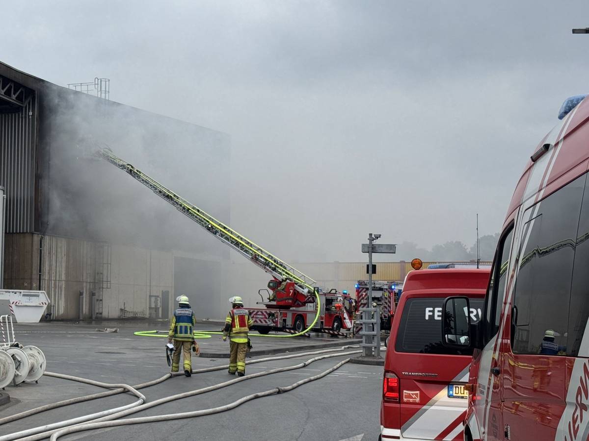 Feuerwehrleute löschen einen Brand auf einem Recyclinghof in Duisburg.