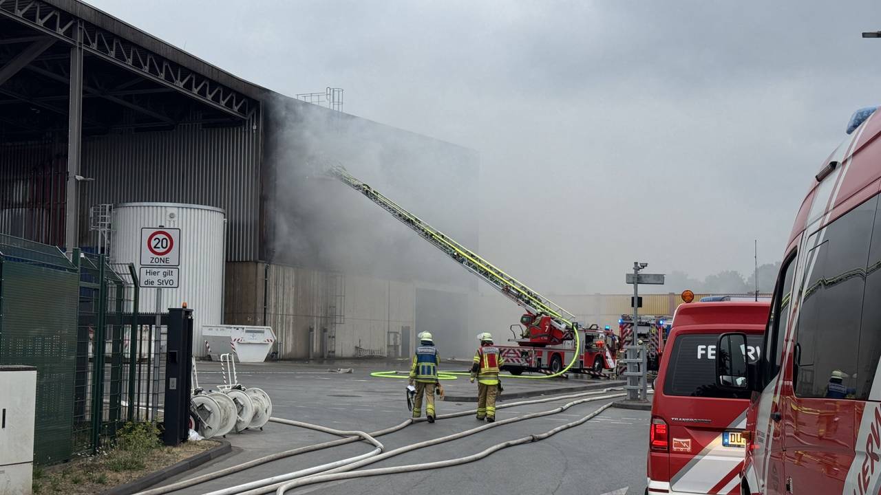 Feuerwehrleute löschen einen Brand auf einem Recyclinghof in Duisburg.