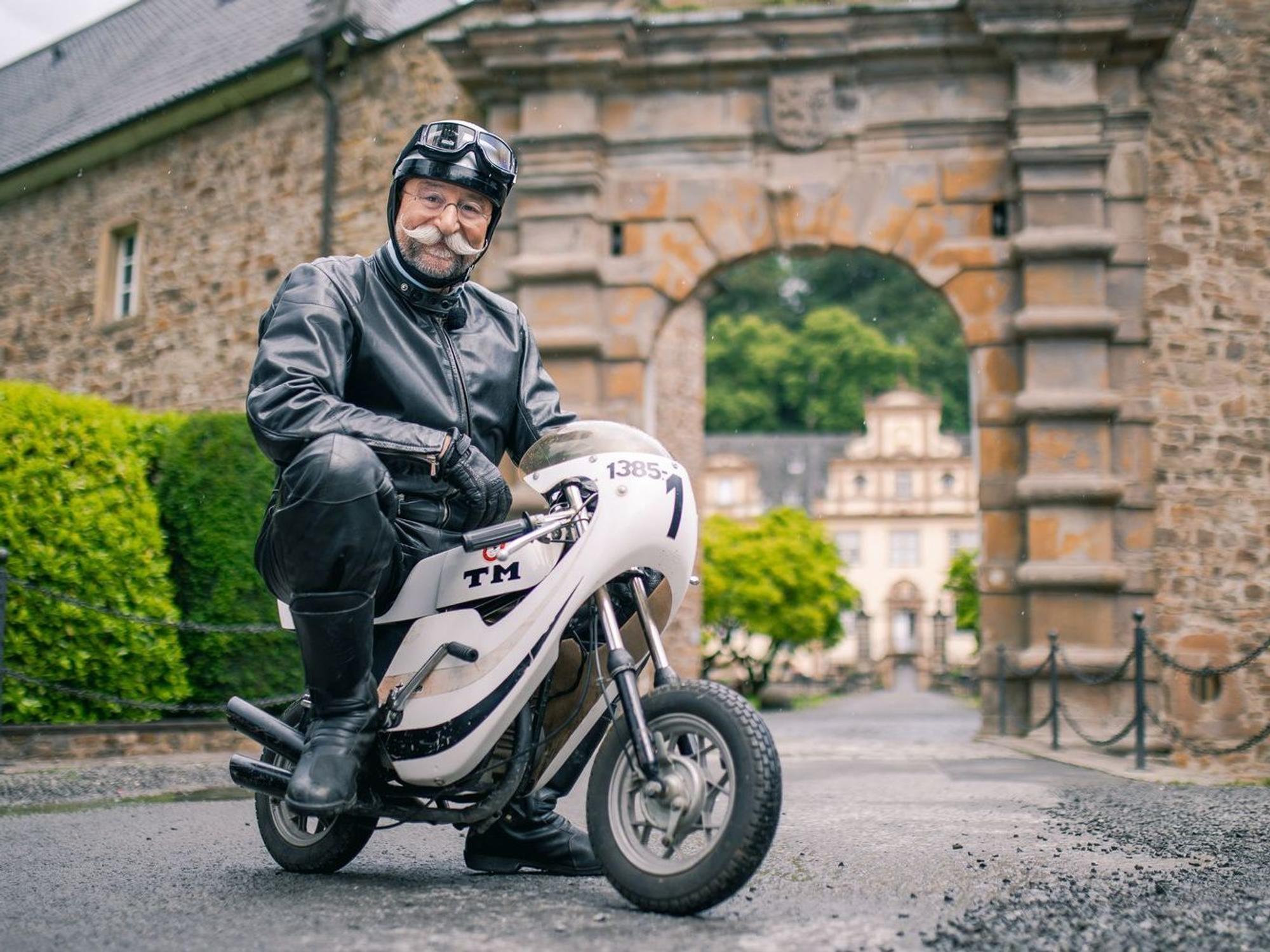 Horst Lichter düst auf zwei Rädern zum pittoresken Schloss Ehreshoven, wo die diesjährige „Bares für Rares XXL“-Sendung aufgezeichnet wurde. Die Ausstrahlung könnte jedoch unterbrochen werden - je nach Wetter. (Bild: ZDF/Eugen Shkolnikov)