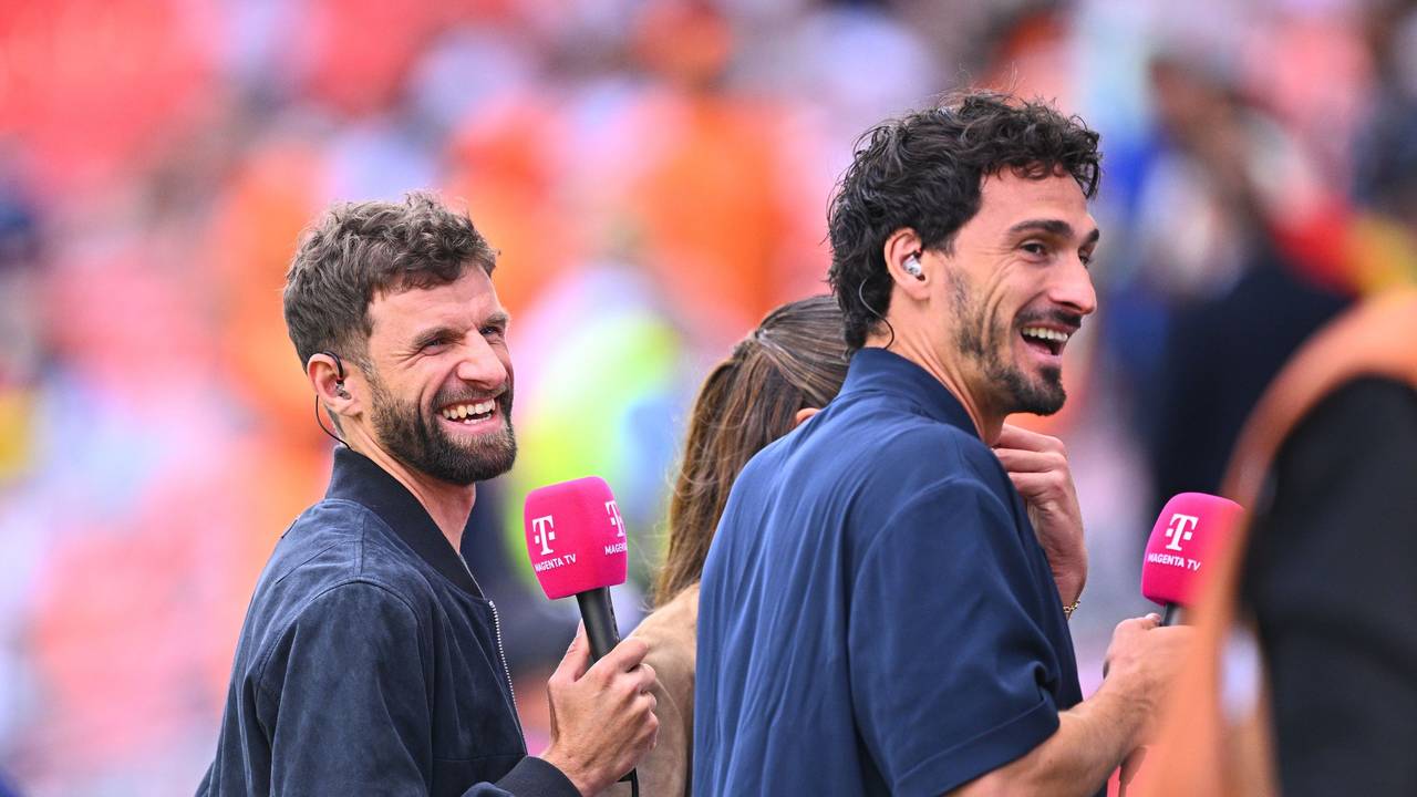 Thomas Müller und Mats Hummels lachen mit MagentaTV-Mikros in der Hand.