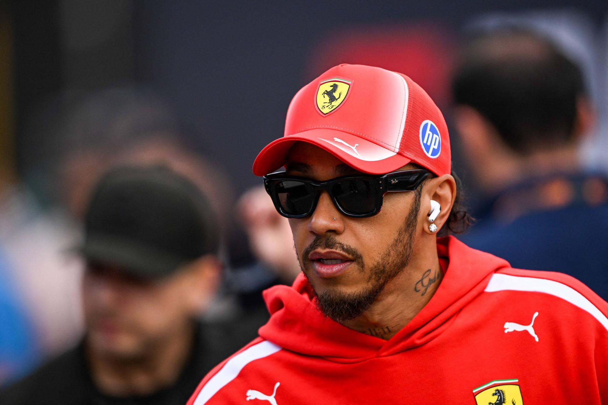 Lewis Hamilton mit Sonnenbrille und Ferrari-Kappe.
