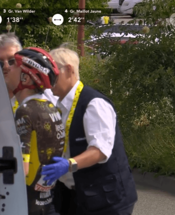 Jonas Vingegaard steigt mit schmerzverzerrtem Gesicht ins Auto des Tourarztes.