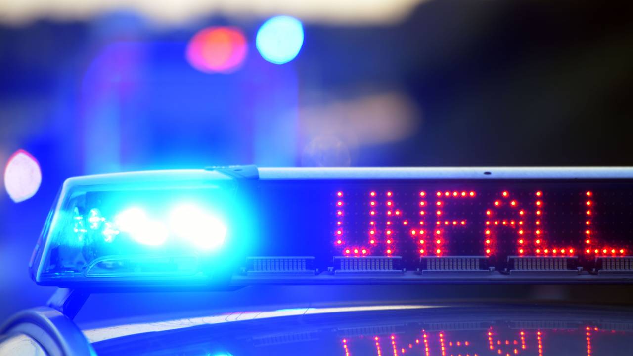 Auf einem Polizeifahrzeug warnt eine Leuchtschrift vor einer Unfallstelle.