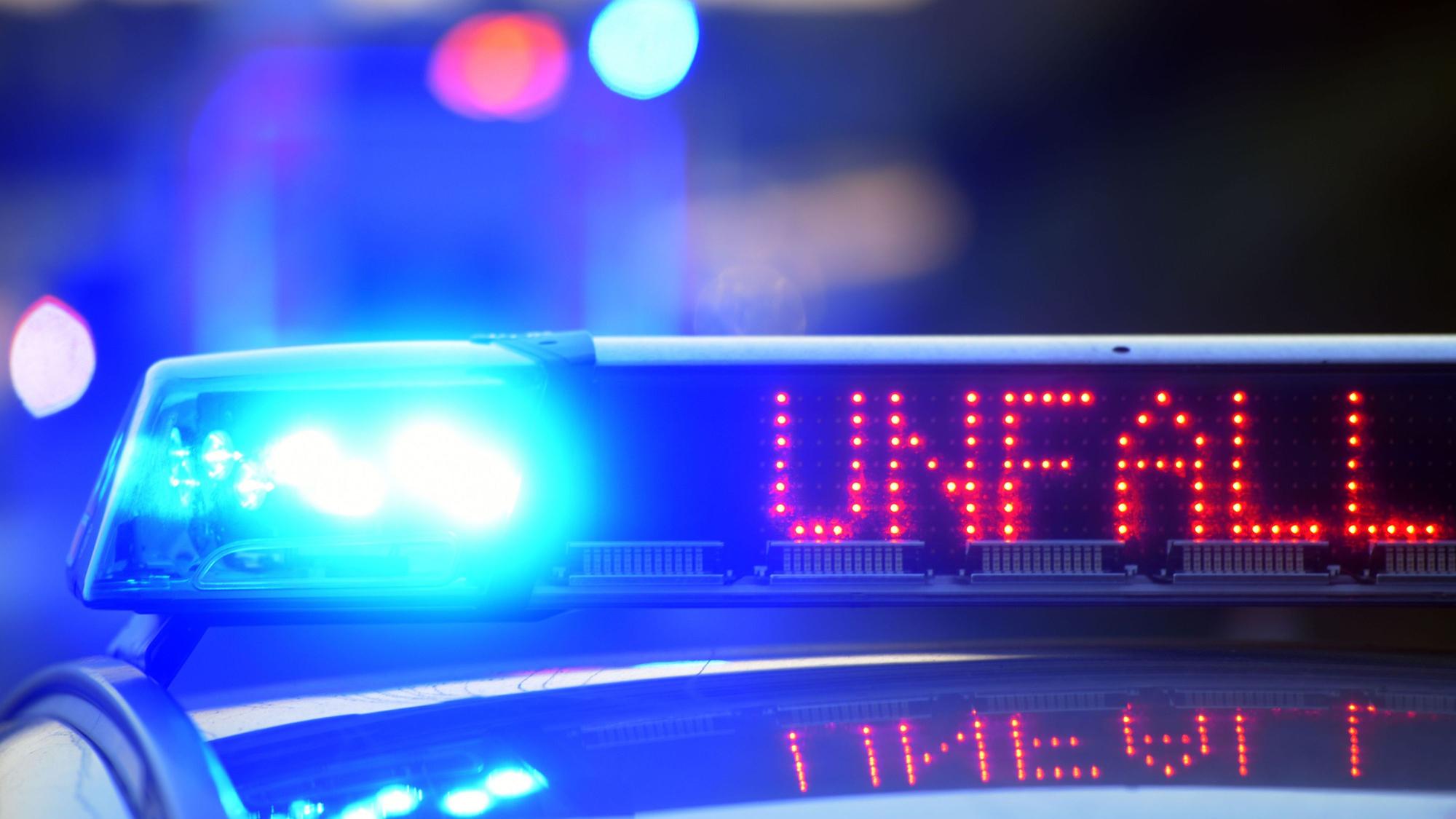 Auf einem Polizeifahrzeug warnt eine Leuchtschrift vor einer Unfallstelle.