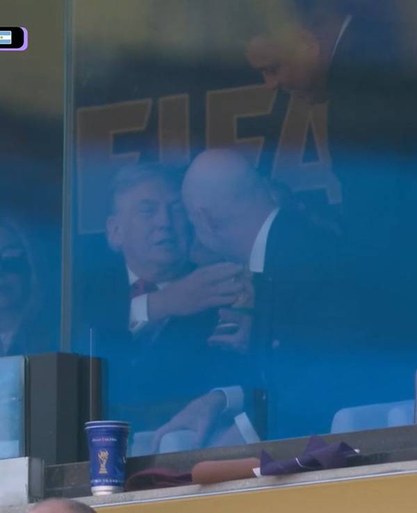 Donald Trump fasst den WM-Pokal an.