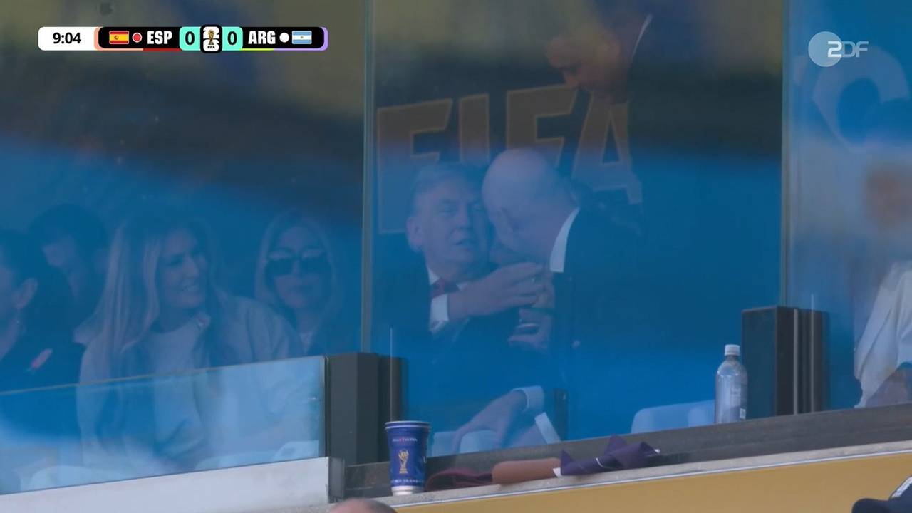 Donald Trump fasst den WM-Pokal an.