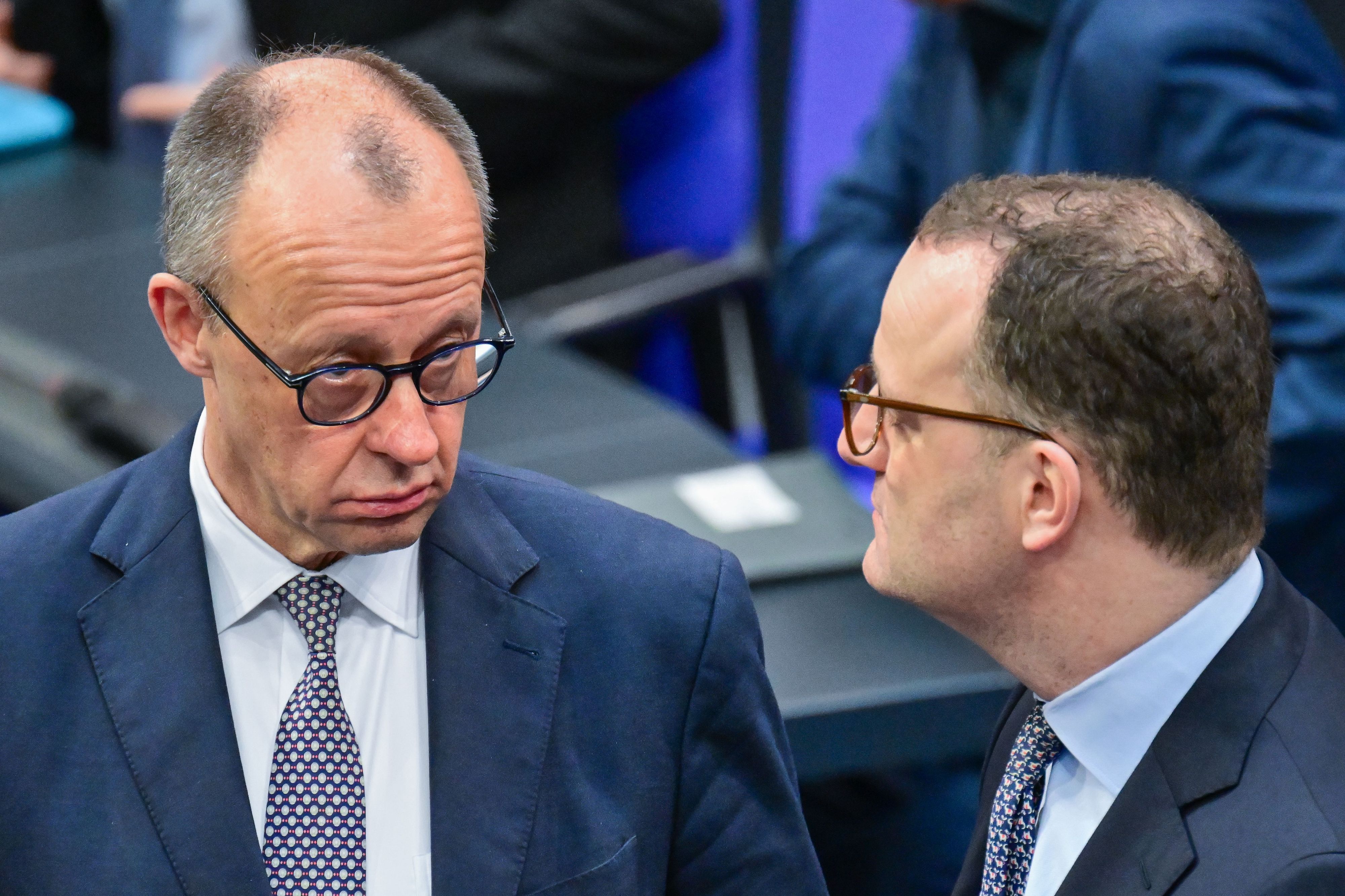 Bundeskanzler Friedrich Merz (CDU) spricht im Deutschen Bundestages mit Jens Spahn.
