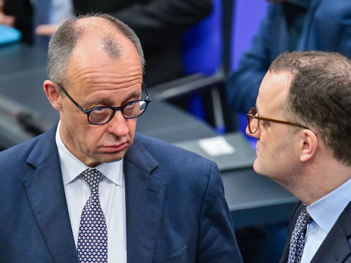 Bundeskanzler Friedrich Merz (CDU) spricht im Deutschen Bundestages mit Jens Spahn.