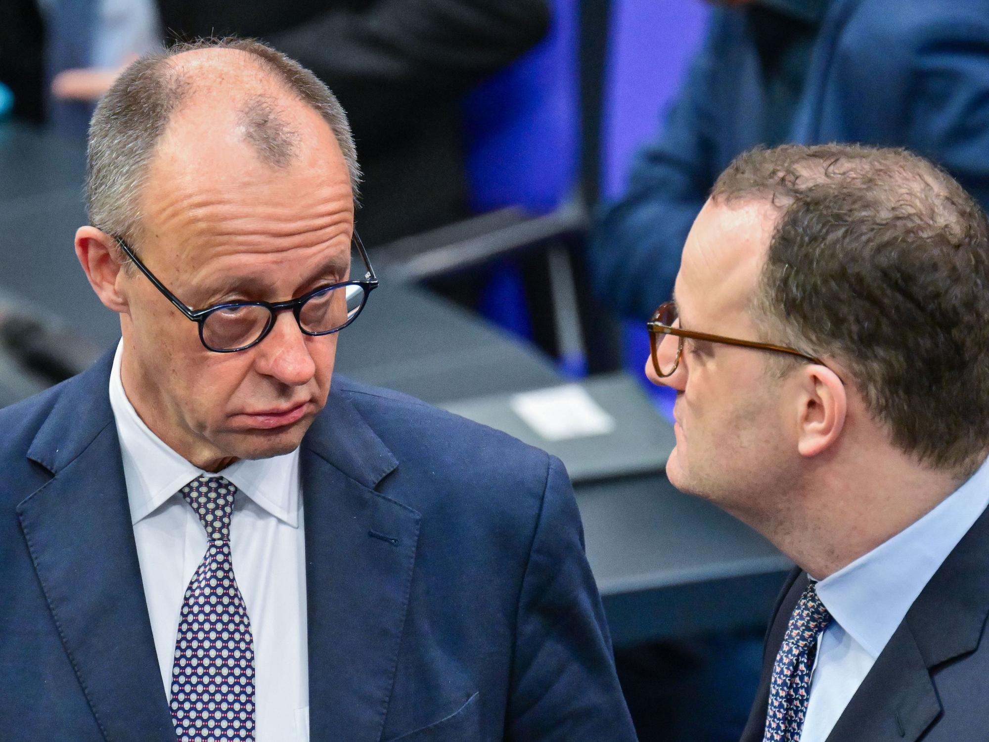Bundeskanzler Friedrich Merz (CDU) spricht im Deutschen Bundestages mit Jens Spahn.