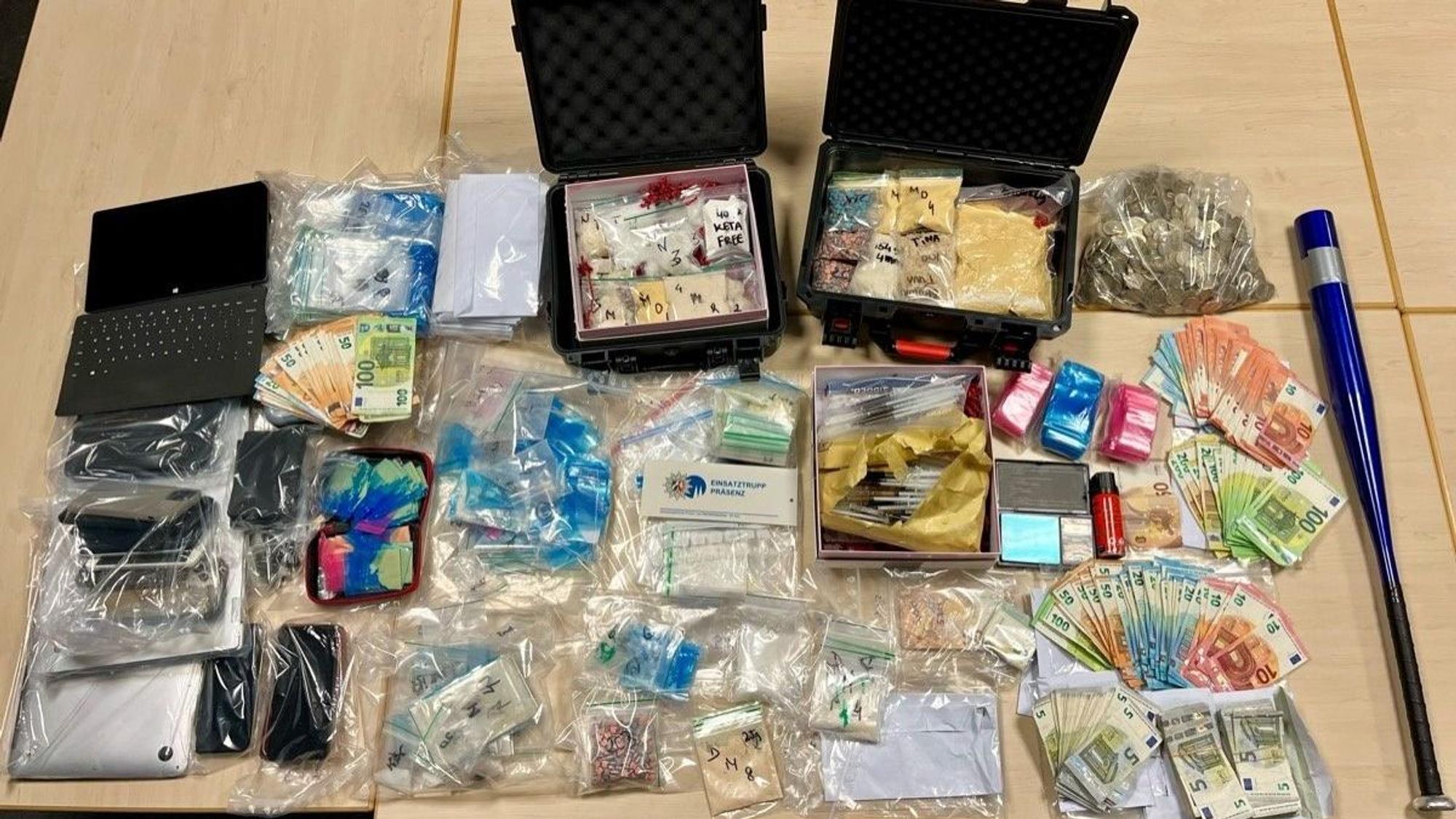 Auf einem Tisch liegen als Beweismittel Drogen, Bargeld und Handys.