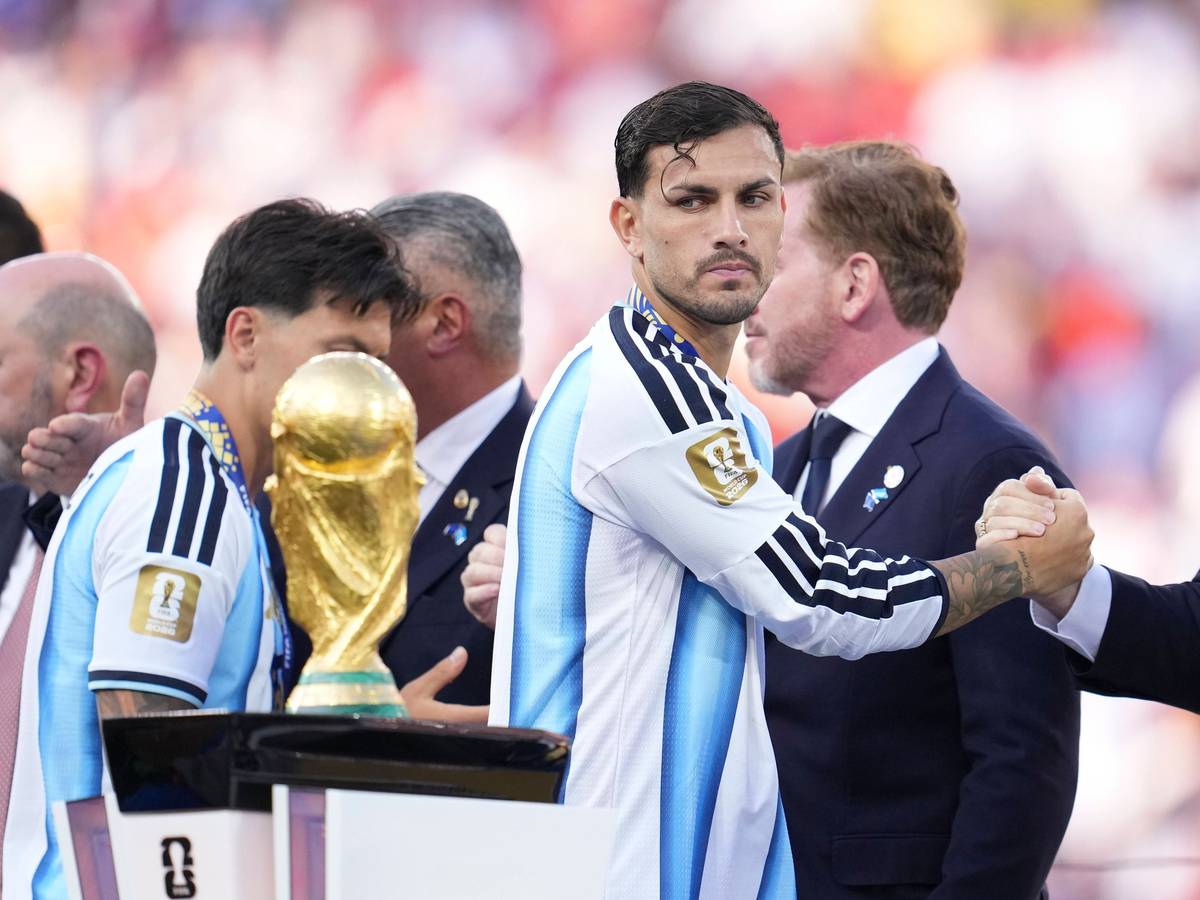Leandro Paredes guckt beim Vorbeigehen auf den WM-Pokal.