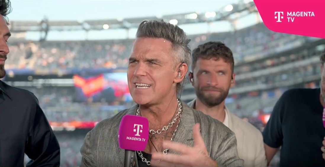 Robbie Williams mit weißem Krümel an der Stirn