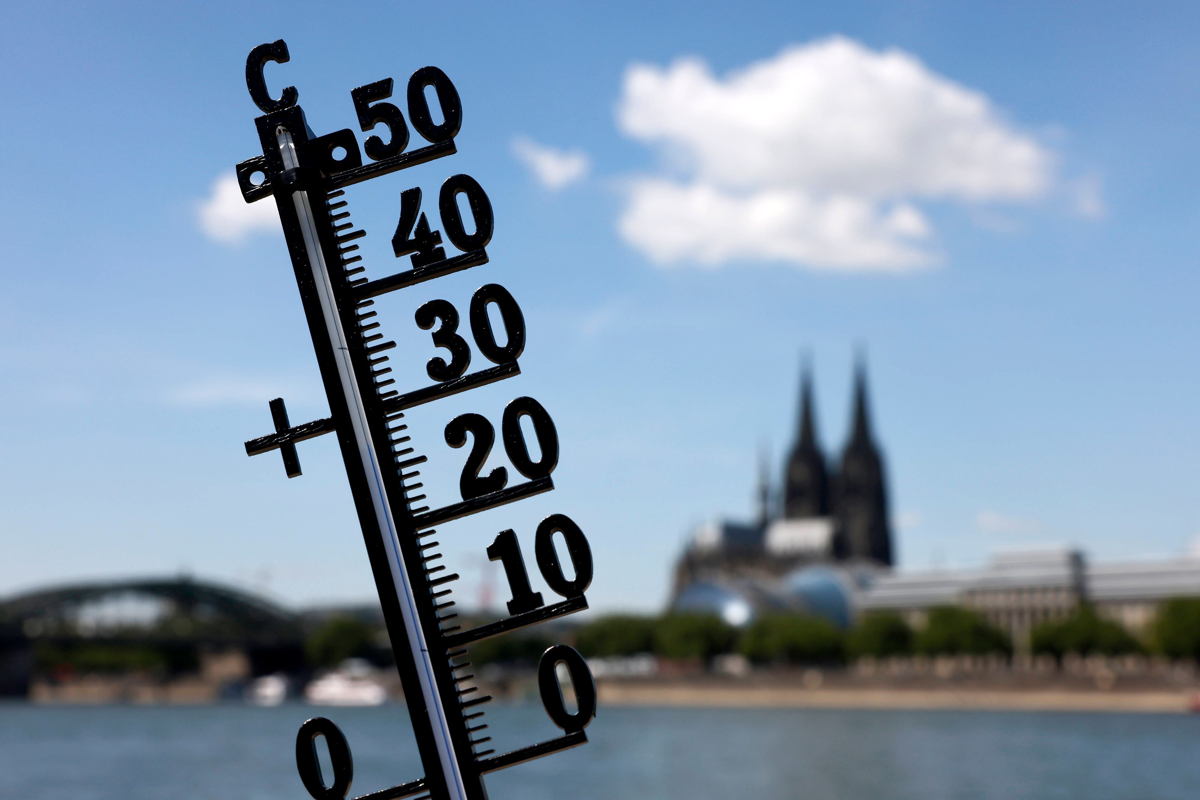 Ein Thermometer zeigt die Temperatur an, im Hintergrund ist der Kölner Dom zu sehen.