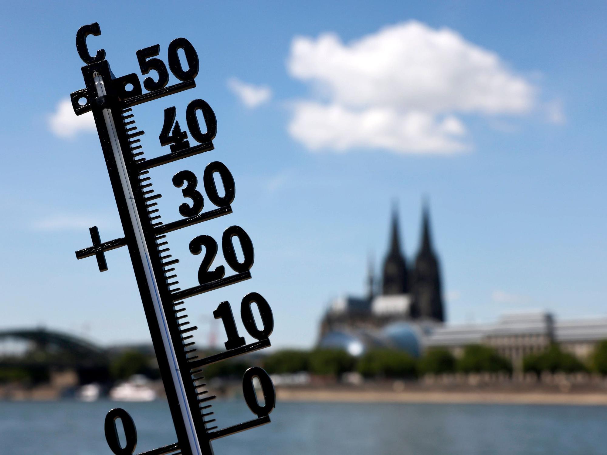 Ein Thermometer zeigt die Temperatur an, im Hintergrund ist der Kölner Dom zu sehen.
