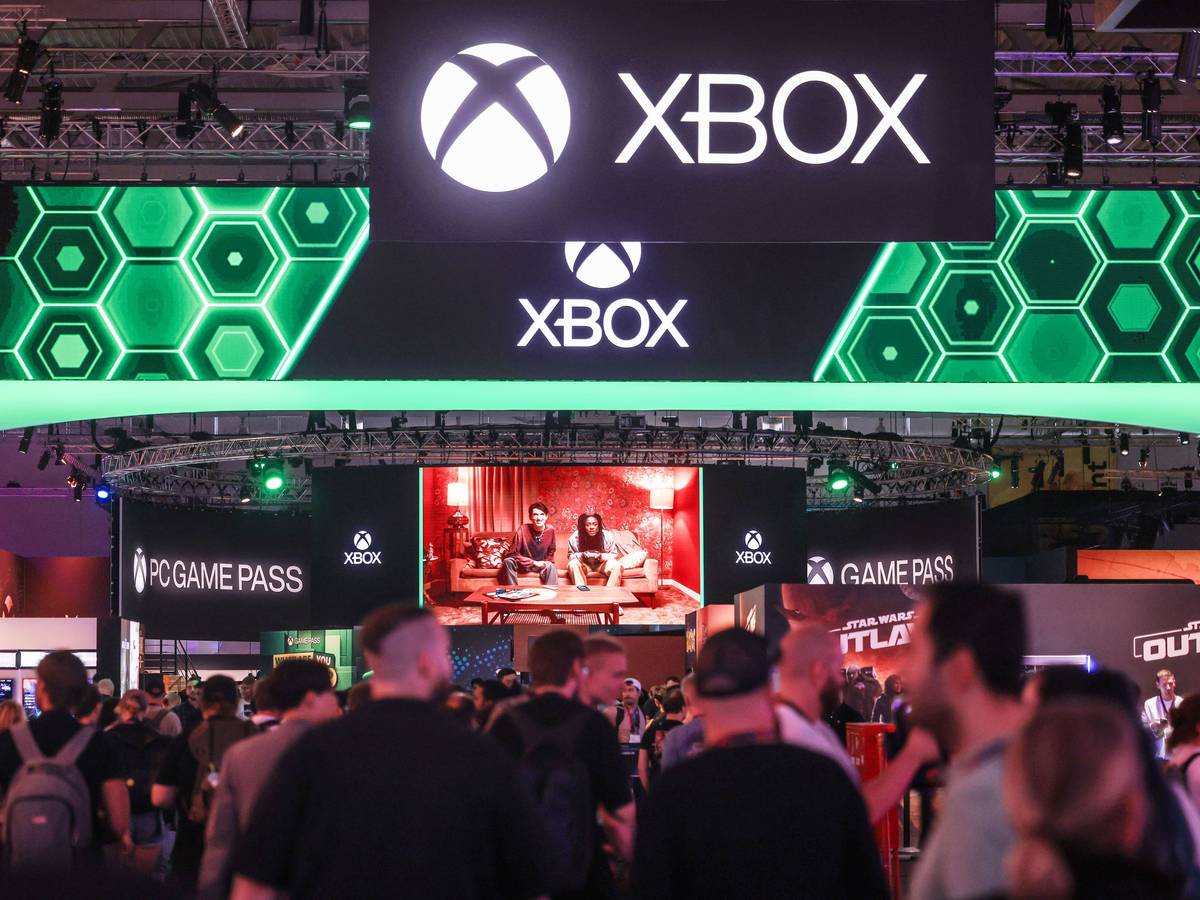 Besucher der Computer- und Videospielmesse Gamescom gehen zum Stand von Microsoft Xbox.