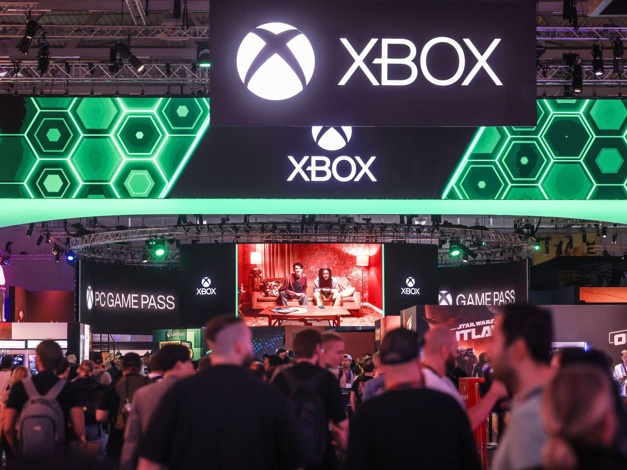 Besucher der Computer- und Videospielmesse Gamescom gehen zum Stand von Microsoft Xbox.