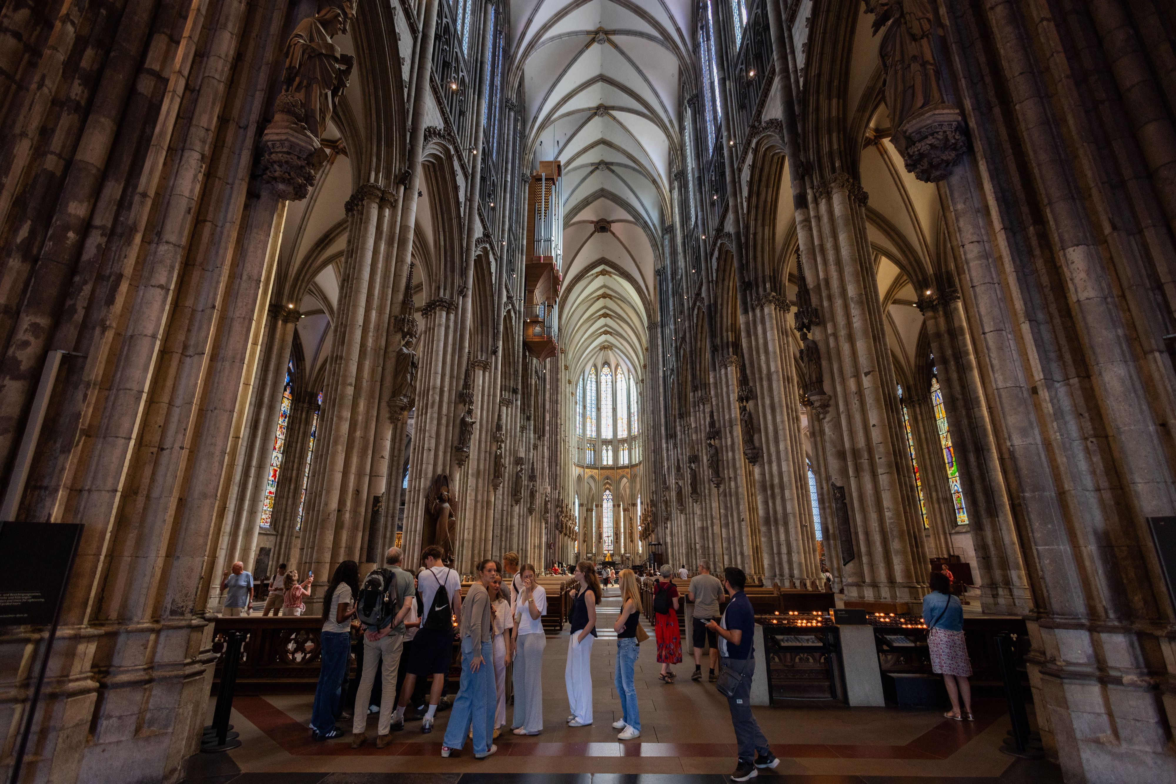Touristen stehen im Kölner Dom.