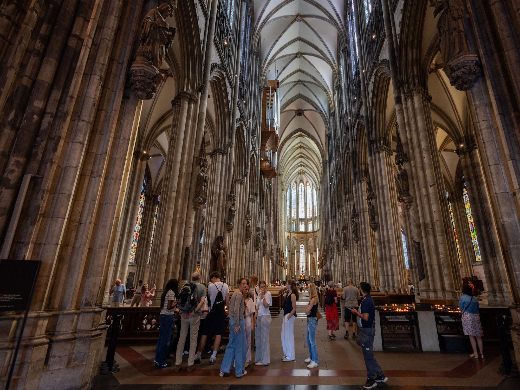 Touristen stehen im Kölner Dom.