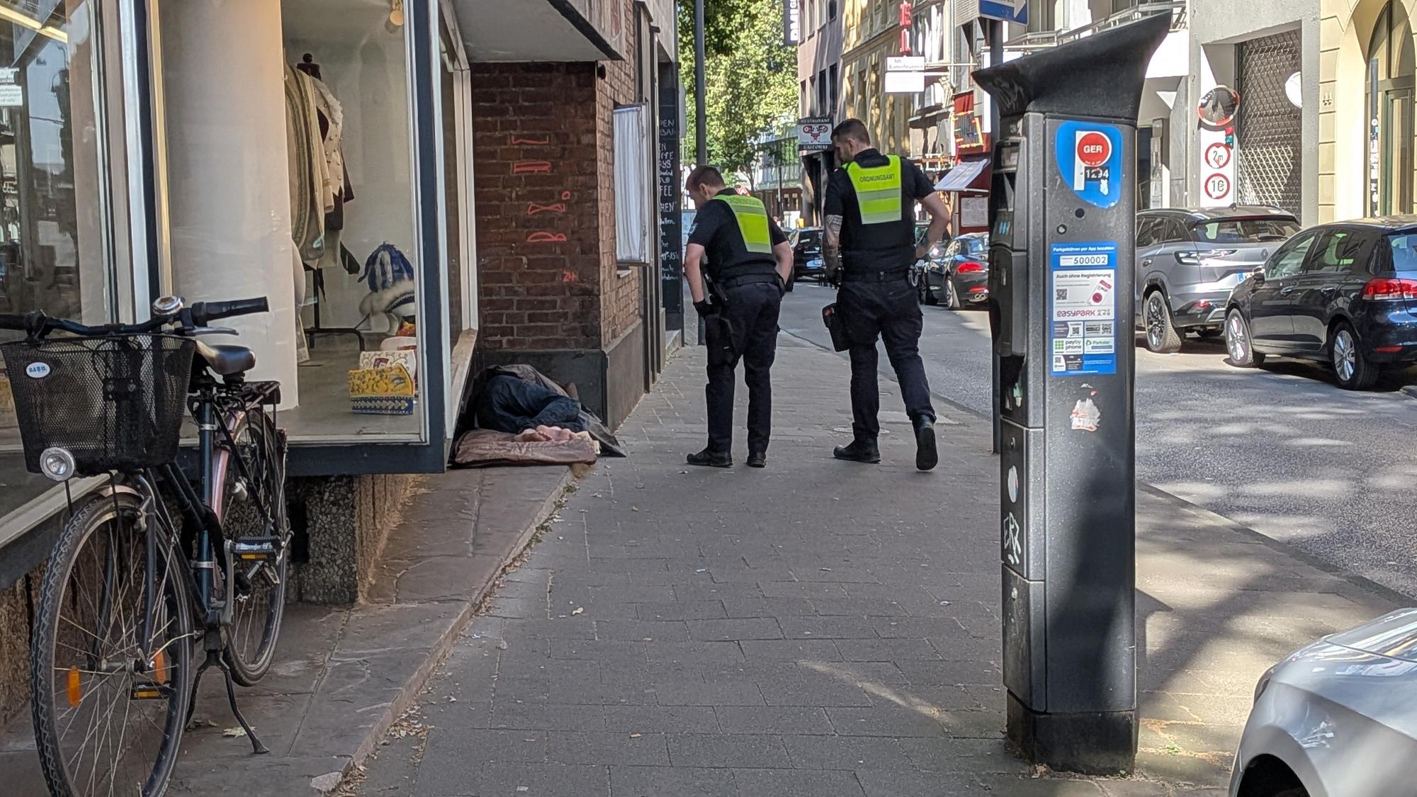 Mitarbeiter des Ordnungsamtes wecken einen Obdachlosen, der in der Nähe des Zeughauses geschlafen hat.