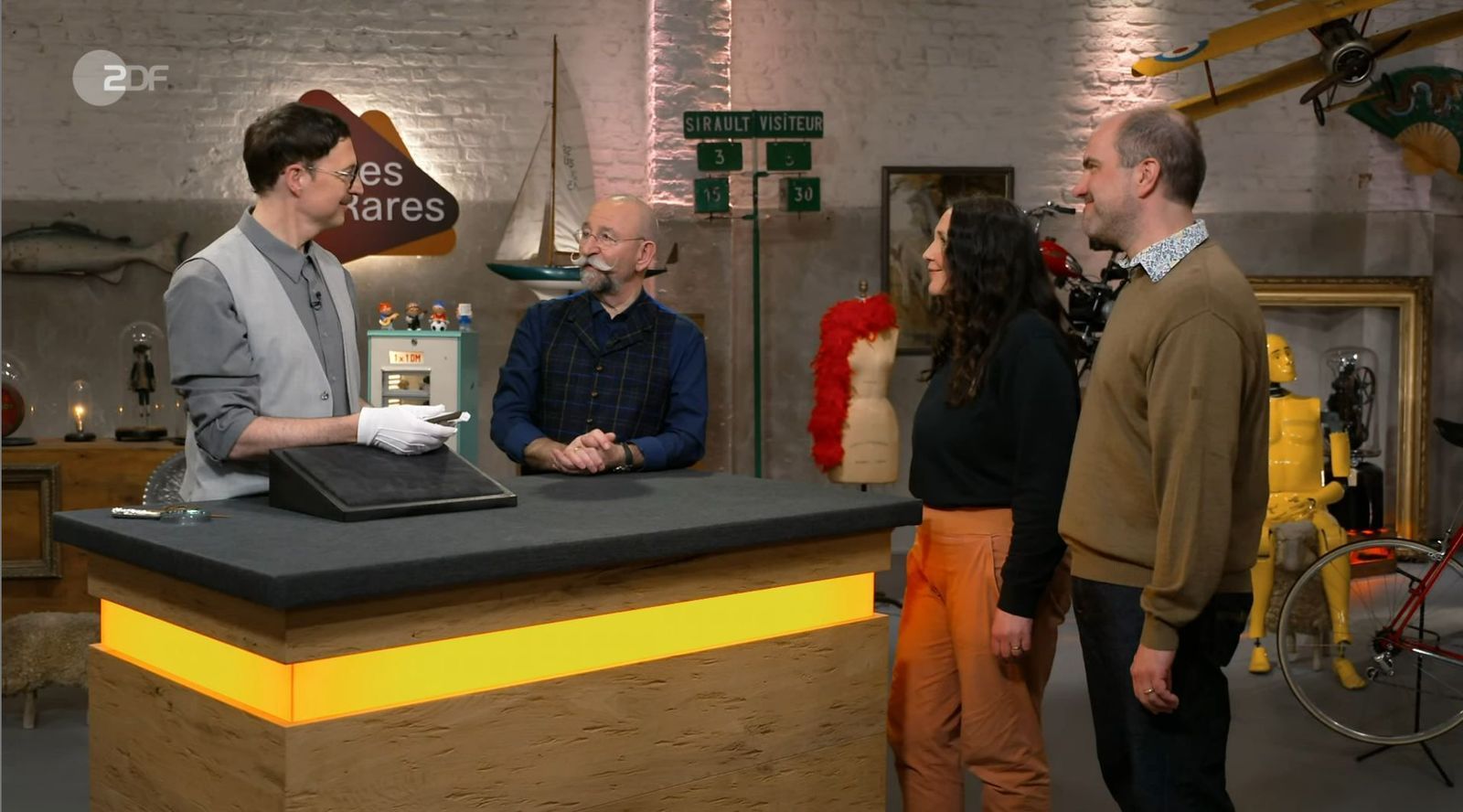 Das Ehepaar Alexandra und Tobias (rechts) möchte in der ZDF-Trödelshow ein vermeintliches „Lesezeichen“ verkaufen, das sich als Kunstwerk entpuppte.  (Bild: ZDF)