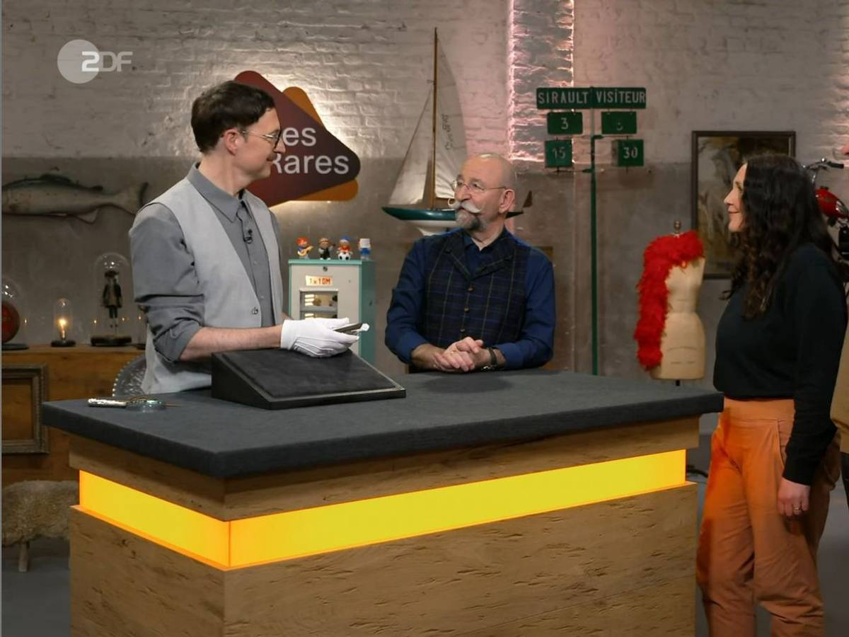 Das Ehepaar Alexandra und Tobias (rechts) möchte in der ZDF-Trödelshow ein vermeintliches „Lesezeichen“ verkaufen, das sich als Kunstwerk entpuppte. (Bild: ZDF)