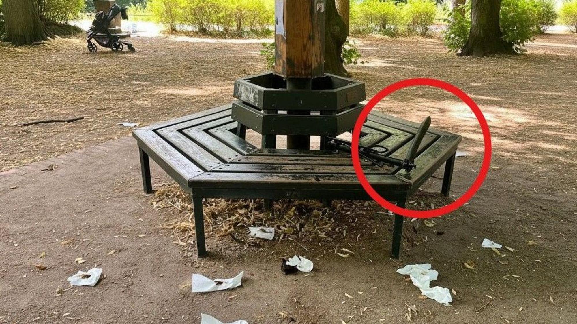 Der Spielplatz im Stadtwald in Köln-Lindenthal kurz nach dem Ekel-Vorfall. Vor der Bank liegen verschmierte Tücher, dazu eine bizarre Vorrichtung an einer Sitzbank.