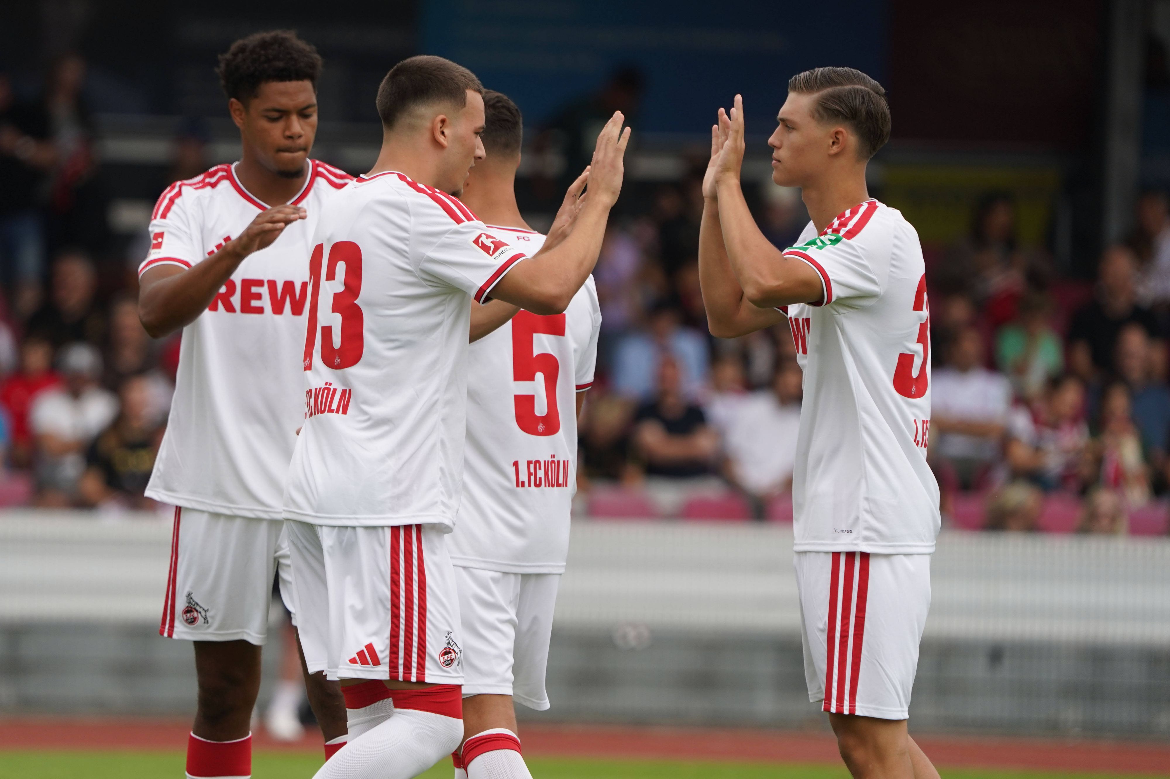 Die FC-Profis klatschen sich in einem Testspiel ab.