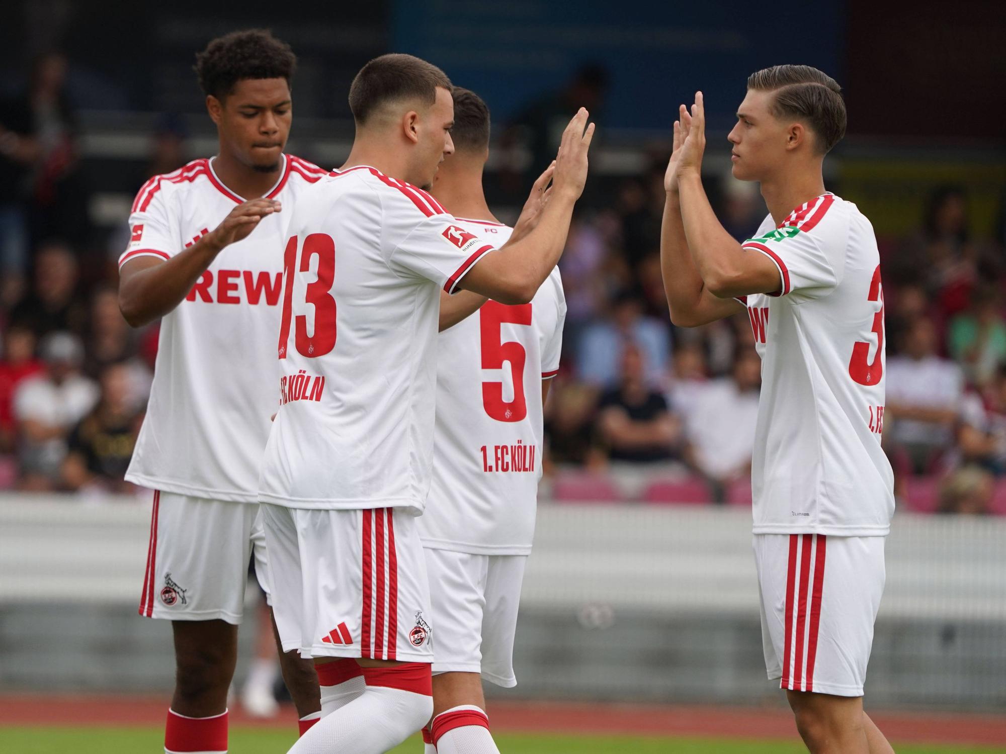 Die FC-Profis klatschen sich in einem Testspiel ab.