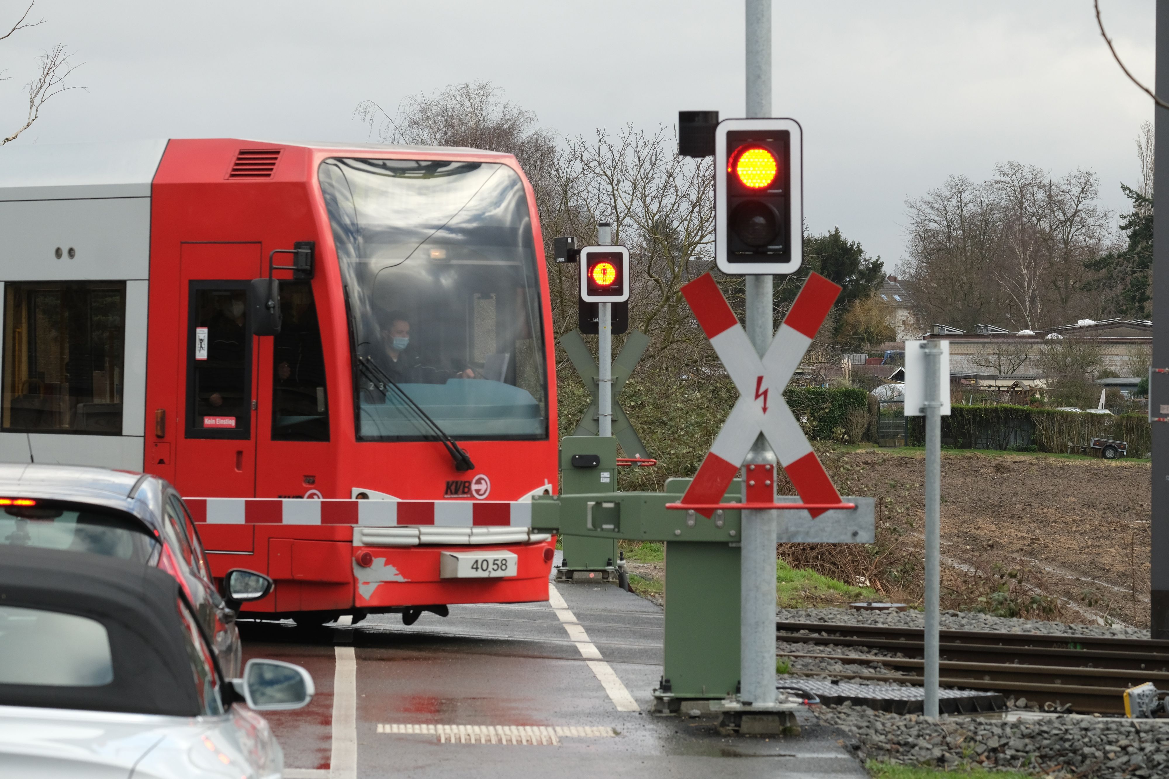 Eine Bahn der KVB passiert einen beschrankten Bahnübergang. (Symbolbild)