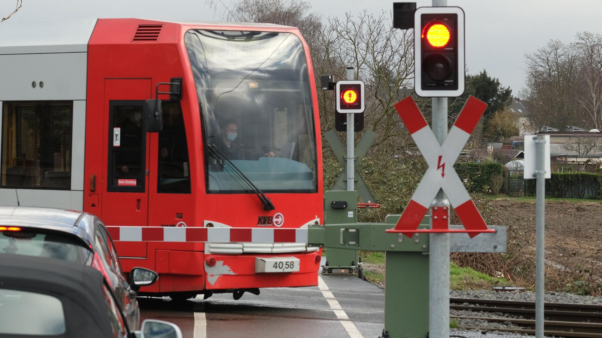 Eine Bahn der KVB passiert einen beschrankten Bahnübergang. (Symbolbild)