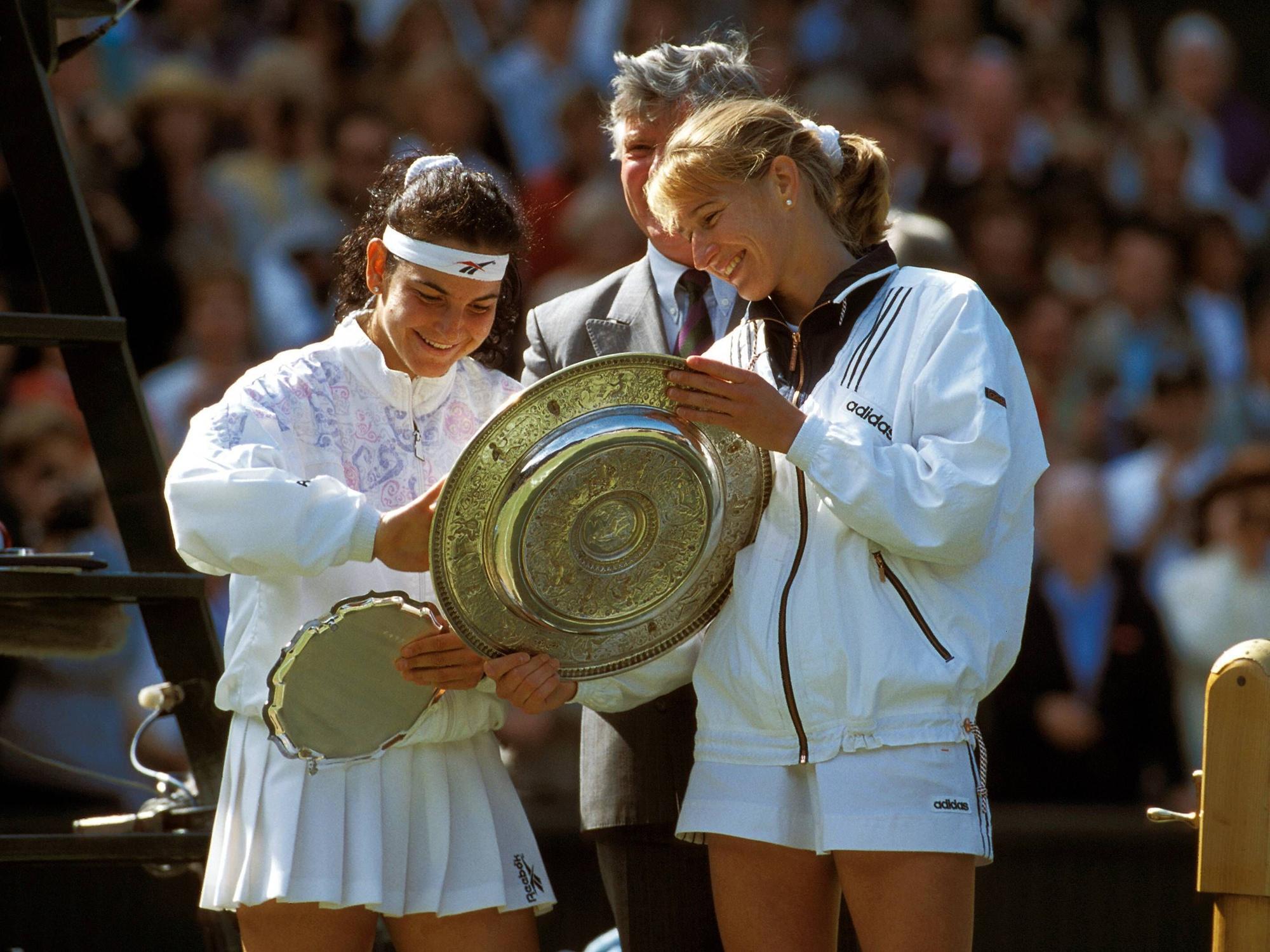 Steffi Graf und Arantxa Sánchez Vicario begutachten lächelnd ihre Trophäen nach dem Wimbledon-Finale.