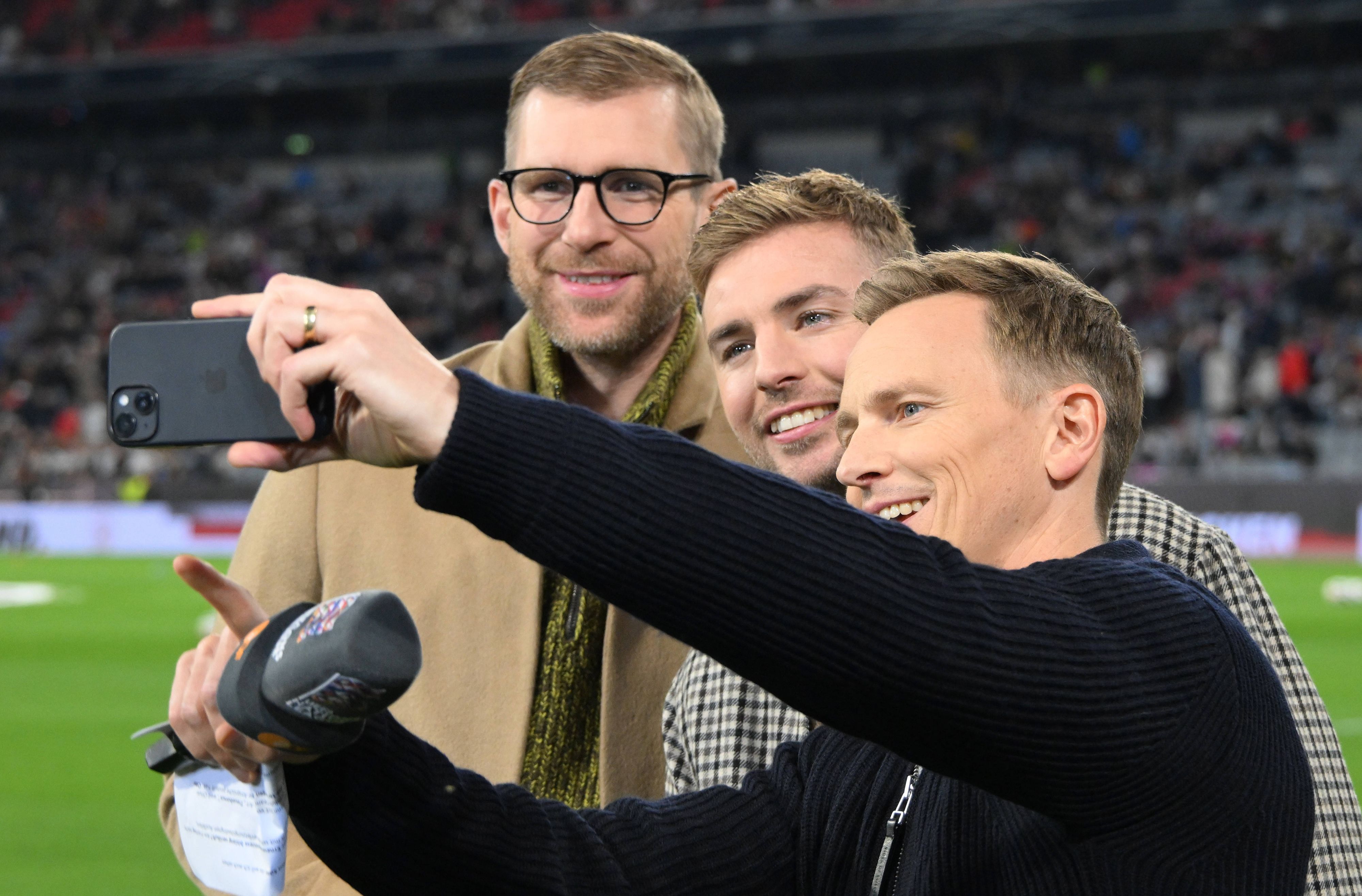 Per Mertesacker (l.), Christoph Kramer und Moderator Jochen Breyer (r.) machen ein Selfie.