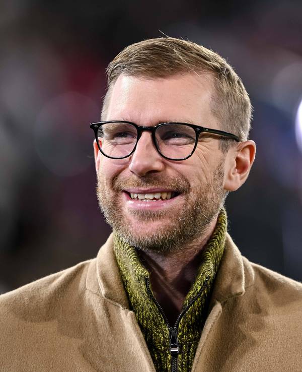 Per Mertesacker steht im Stadion und hat gute Laune.