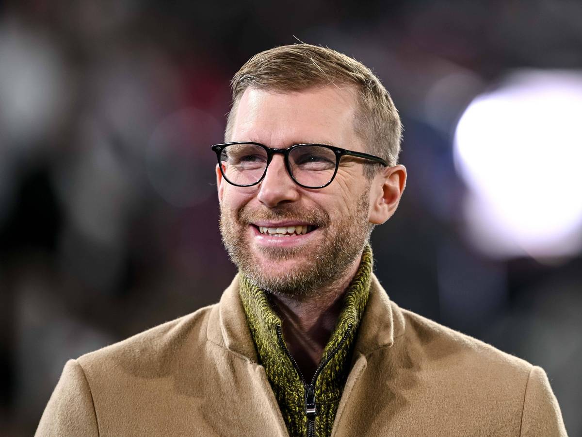Per Mertesacker steht im Stadion und hat gute Laune.
