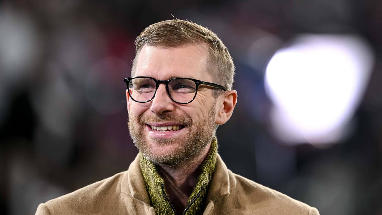 Per Mertesacker steht im Stadion und hat gute Laune.
