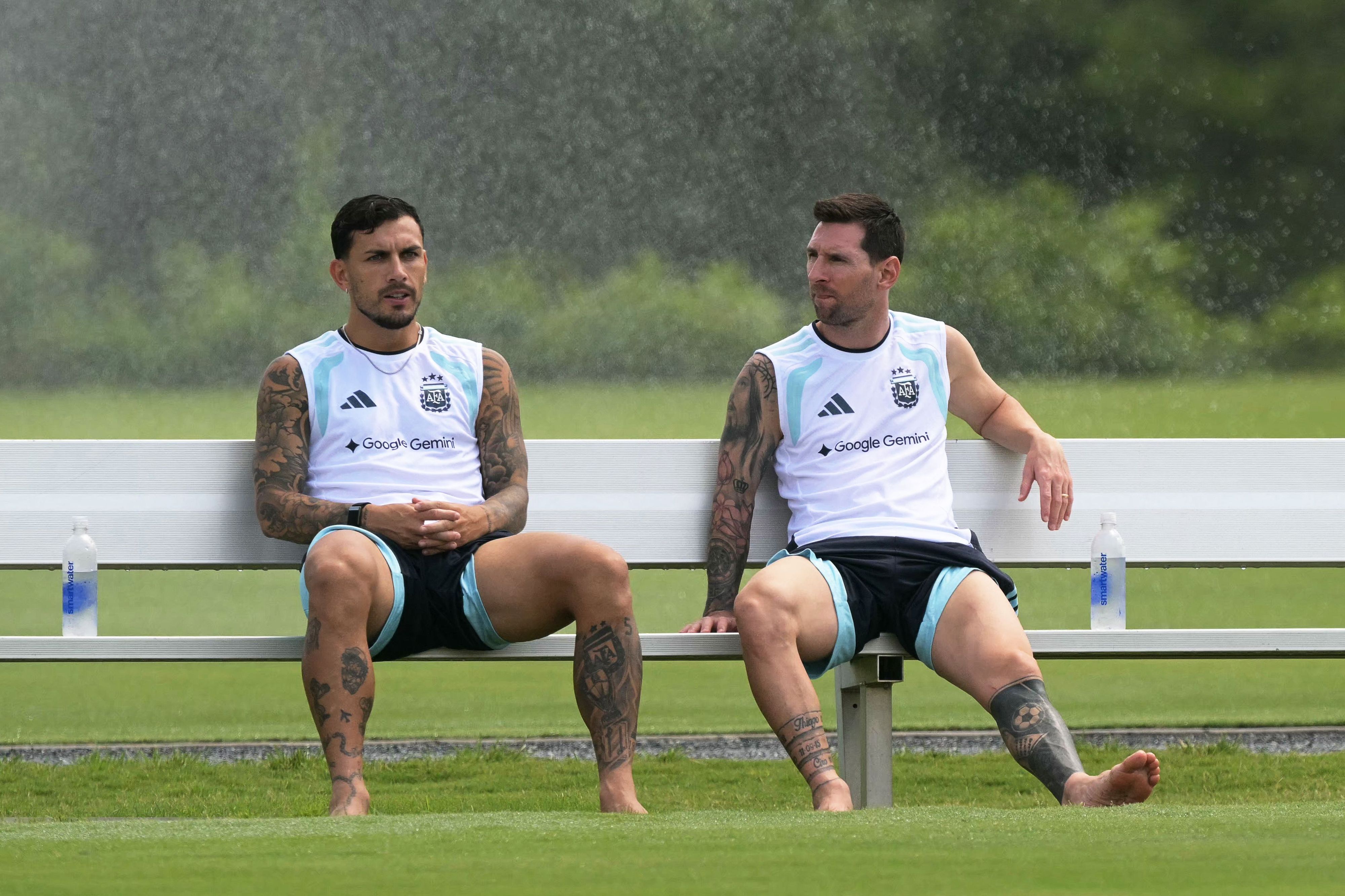 Leandro Paredes und Lionel Messi sitzen auf einer Bank.